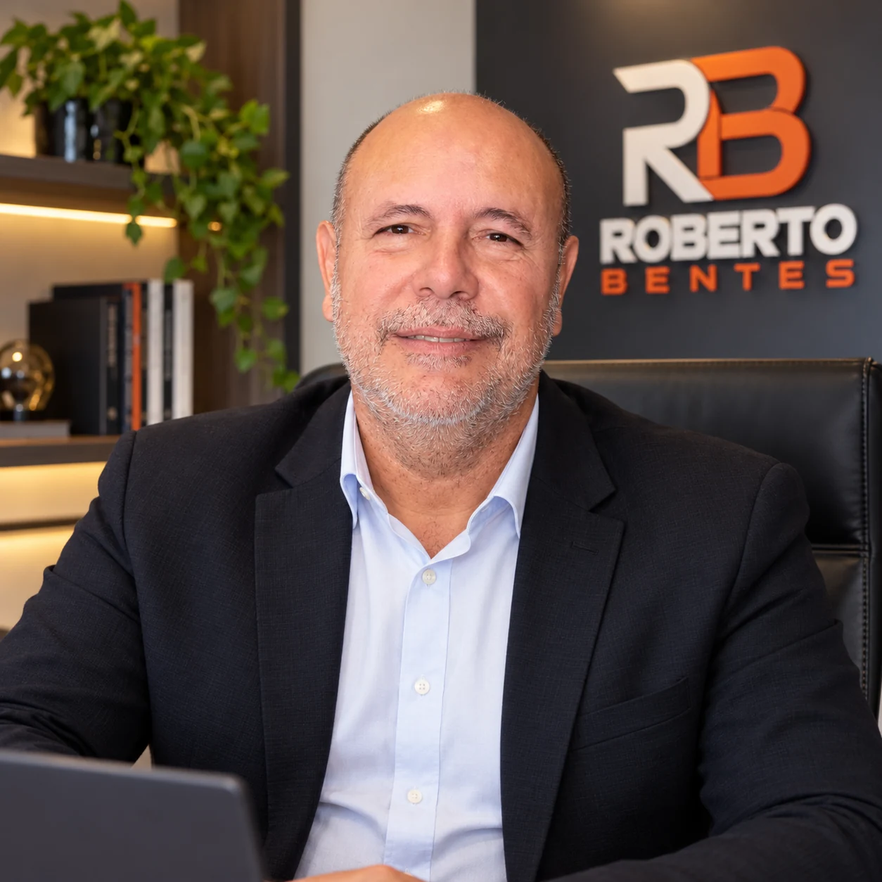 Roberto Bentes sentado em seu escritório, com blazer escuro e camisa clara